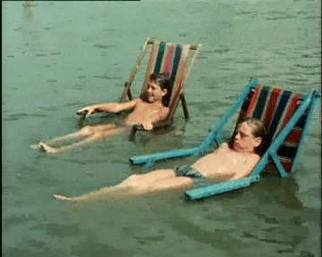 submerged deck chairs gif Two young boys sit on deck chairs that are submerged in water