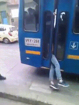 How not to commute gif A blue bus drives away with a mans legs dangling out the door