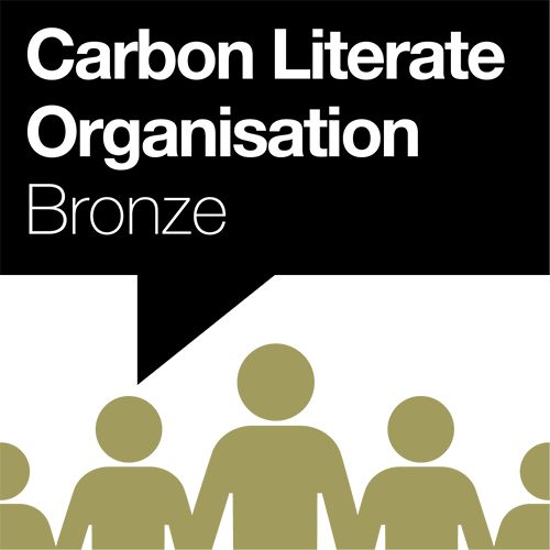 Carbon Literate Organisation Bronze logo Carbon Literate Organisation Bronze text in black speech bubble with 5 gold people graphics.