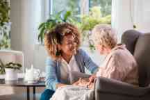 Friendly nurse supporting an eldery lady