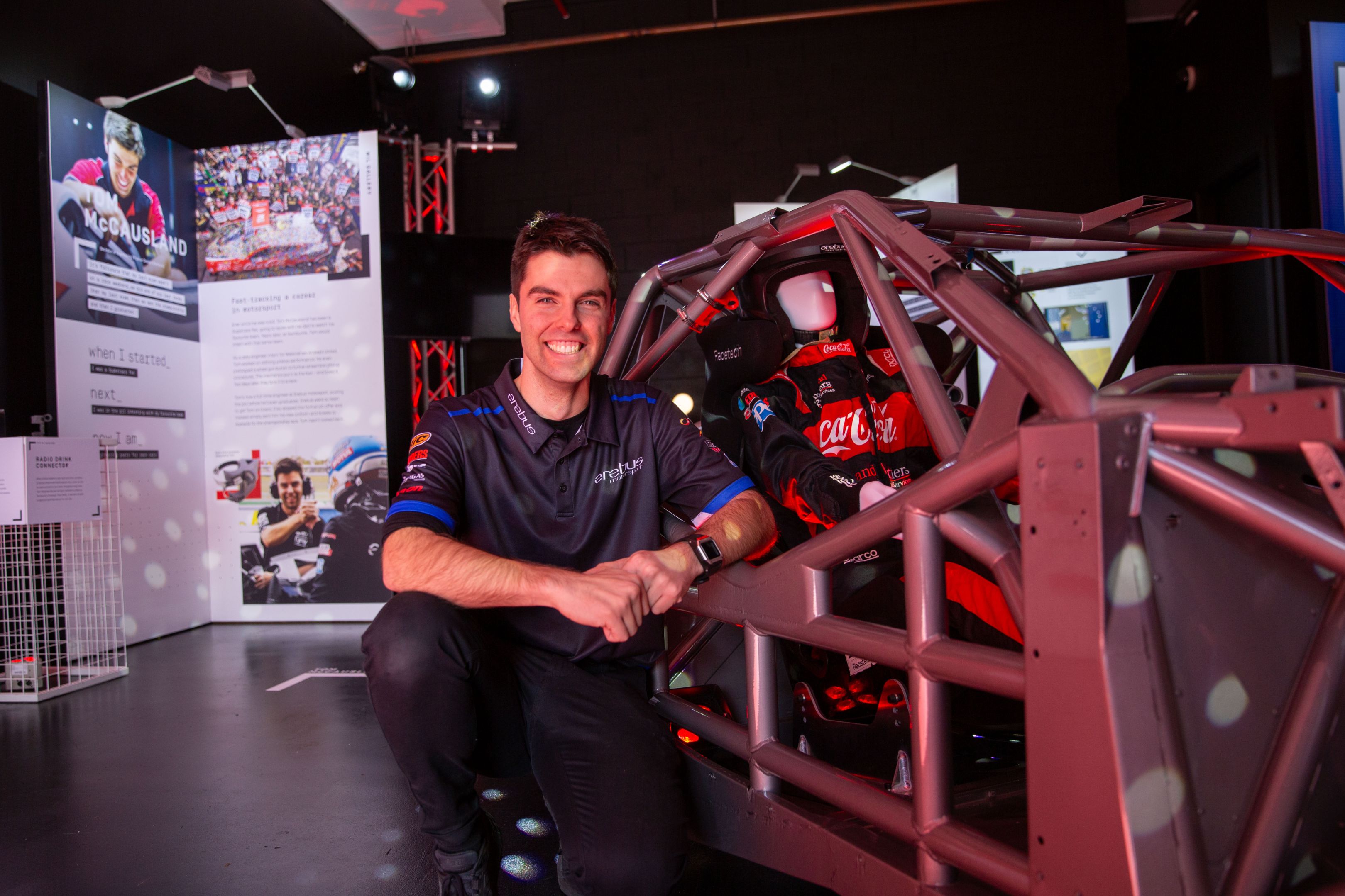 Swinburne student Tom poses in front of a racing car frame inside the Work Integrated Learning gallery at Swinburne Open Day 2024.