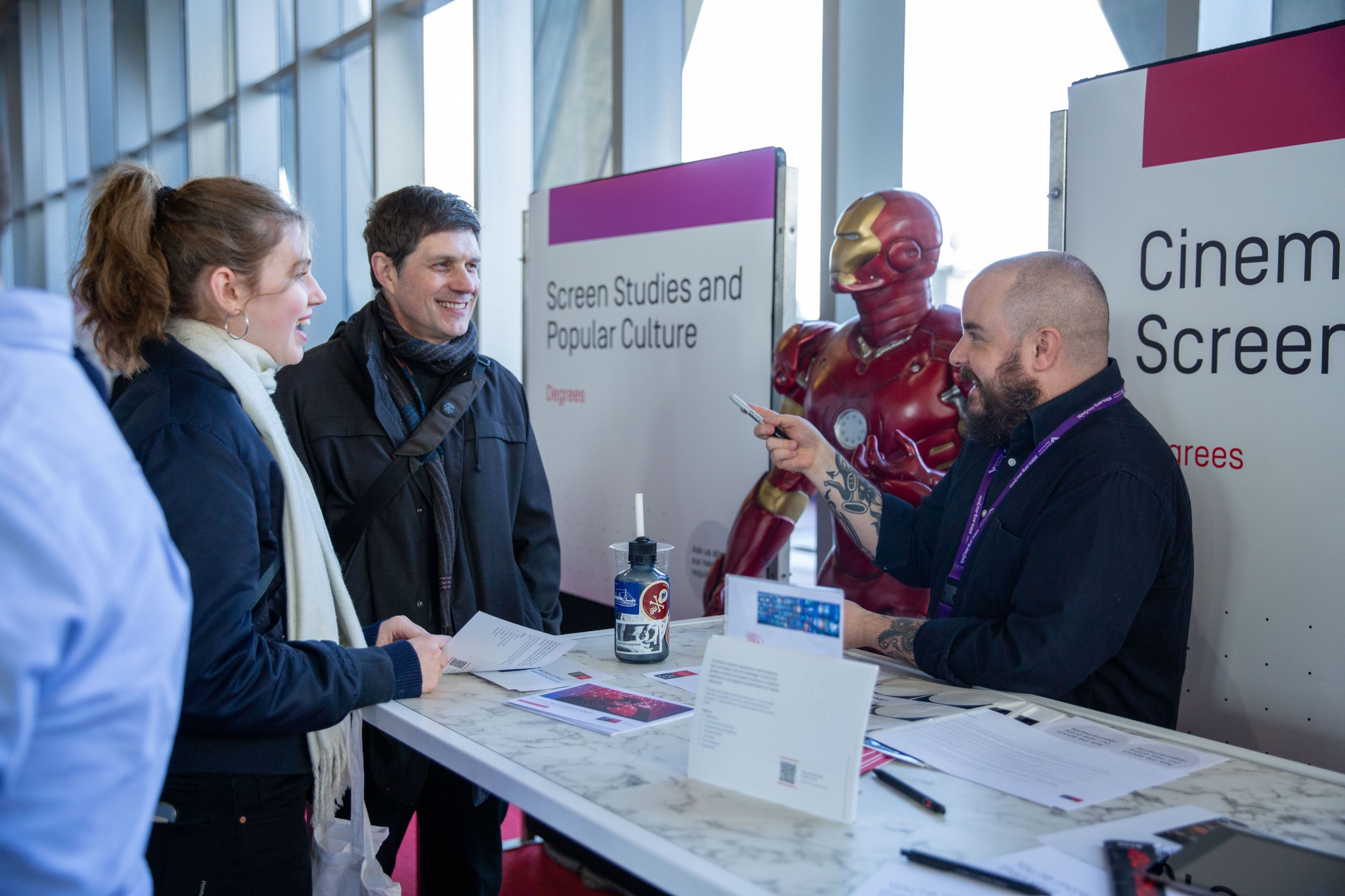 Open Day 2024 Two guests speaking with an academic at a Cinema and Screen Studies booth at Swinburne Open Day 2024.