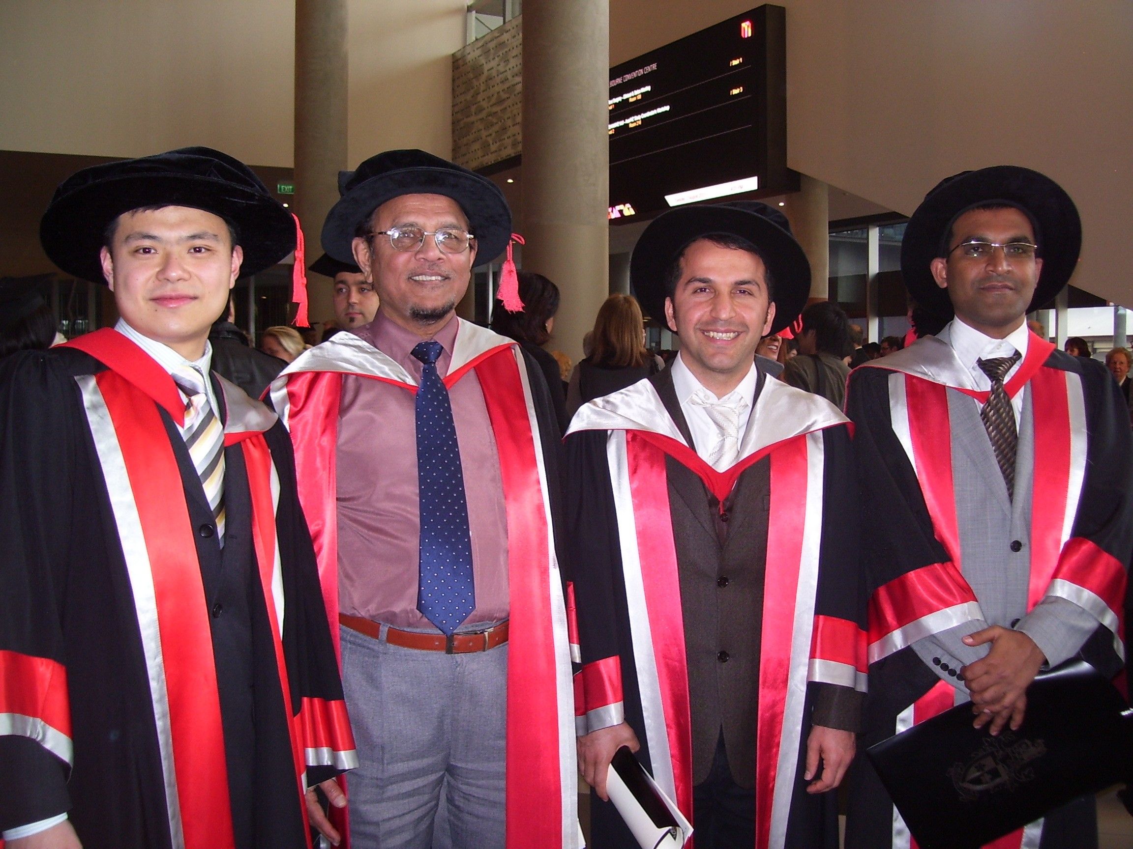 Professor Masood with his PhD graduates: Dr Xuan Zhi Wang, Dr Mostafa Nikzad and Dr Abul Saifullah Professor Masood stands second from the left with three of his 2021 PhD graduates. All are wearing robes with the Swinburne colours, red, white and black.