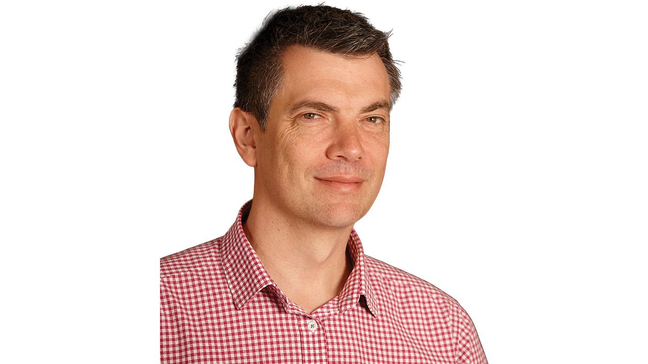 Will Joske, Principal Building Informational Modelling Adviser, professional headshot. A professional portrait headshot of Will Joske wearing a red and white checkered shirt.