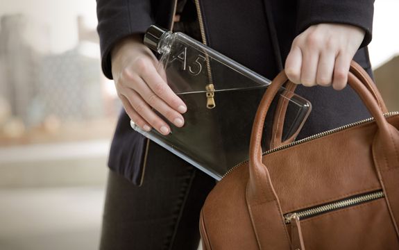 A person is pulling a memobottle out of their bag