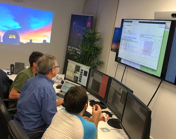 Three researchers observing data from the W M Keck Observatory