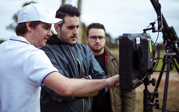 Swinburne alumnus and filmmaker, Nick Kozakis (centre) on set of the ‘Dance Monkey’ music video.