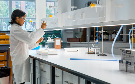 A woman stands in a lab doing medical testing