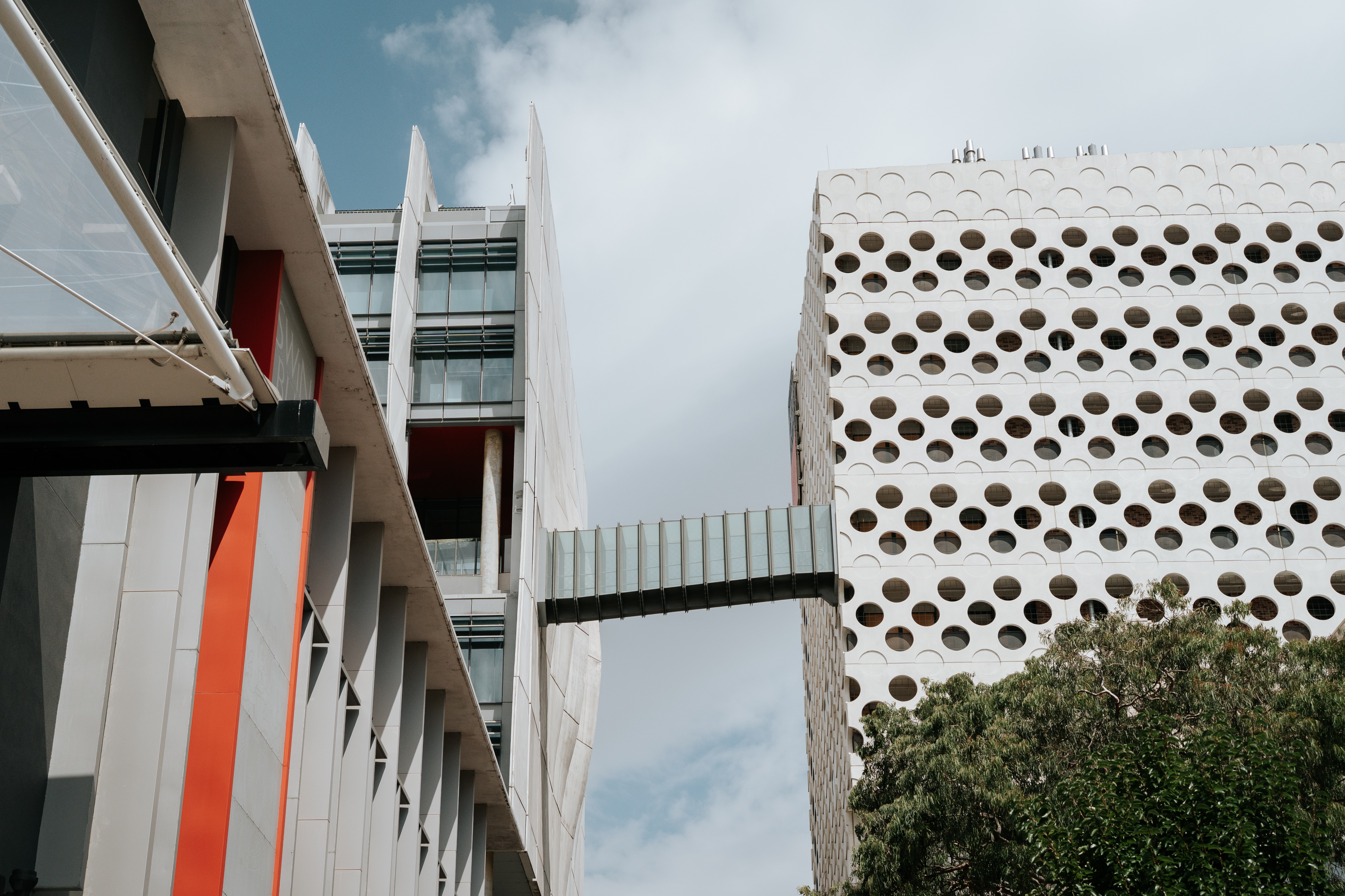 Shot of the ACMD and ATC building bridge at the Hawthorn campus, looking up above against a cloudy sky. 