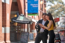 2 photography students examining a camera near Glenferrie railway station