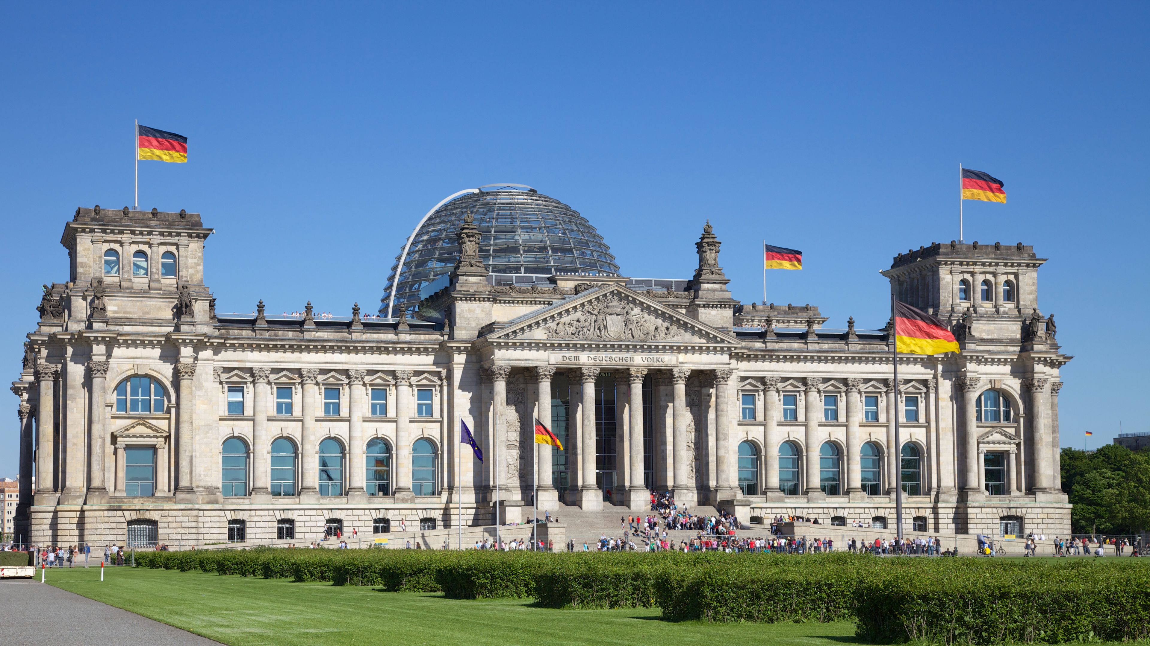 STOCK Reichstag in Berlin Reichstag in Berlin with German flags and blue sky