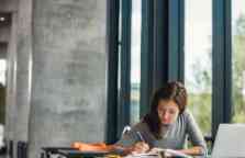 Young female student studying in library.