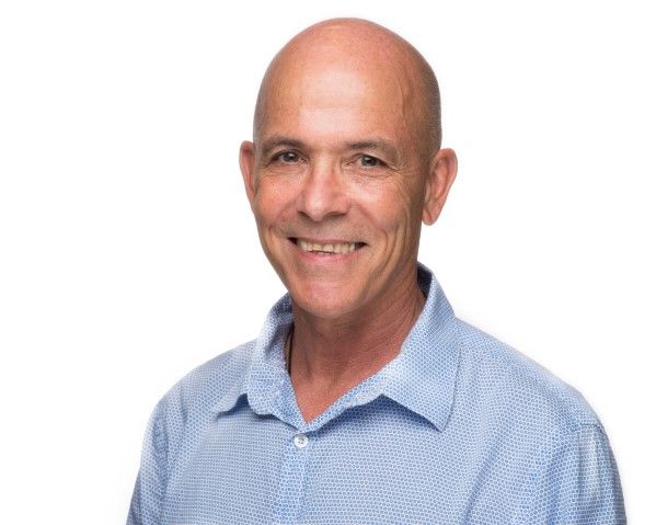 Headshot of man in blue button up shirt. 