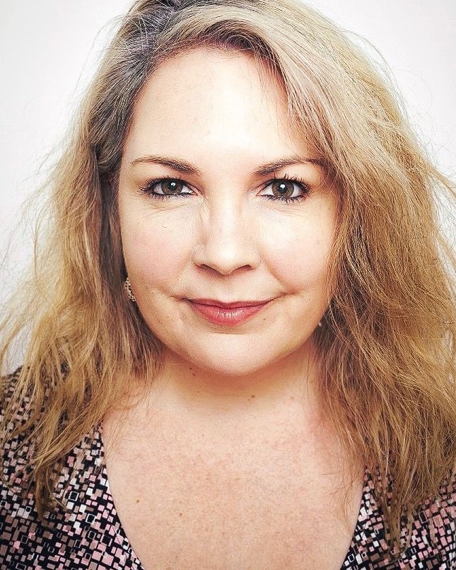 Headshot of woman with blond hair wearing floral dress
