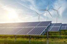solar panels and wind generators under blue sky on sunset
