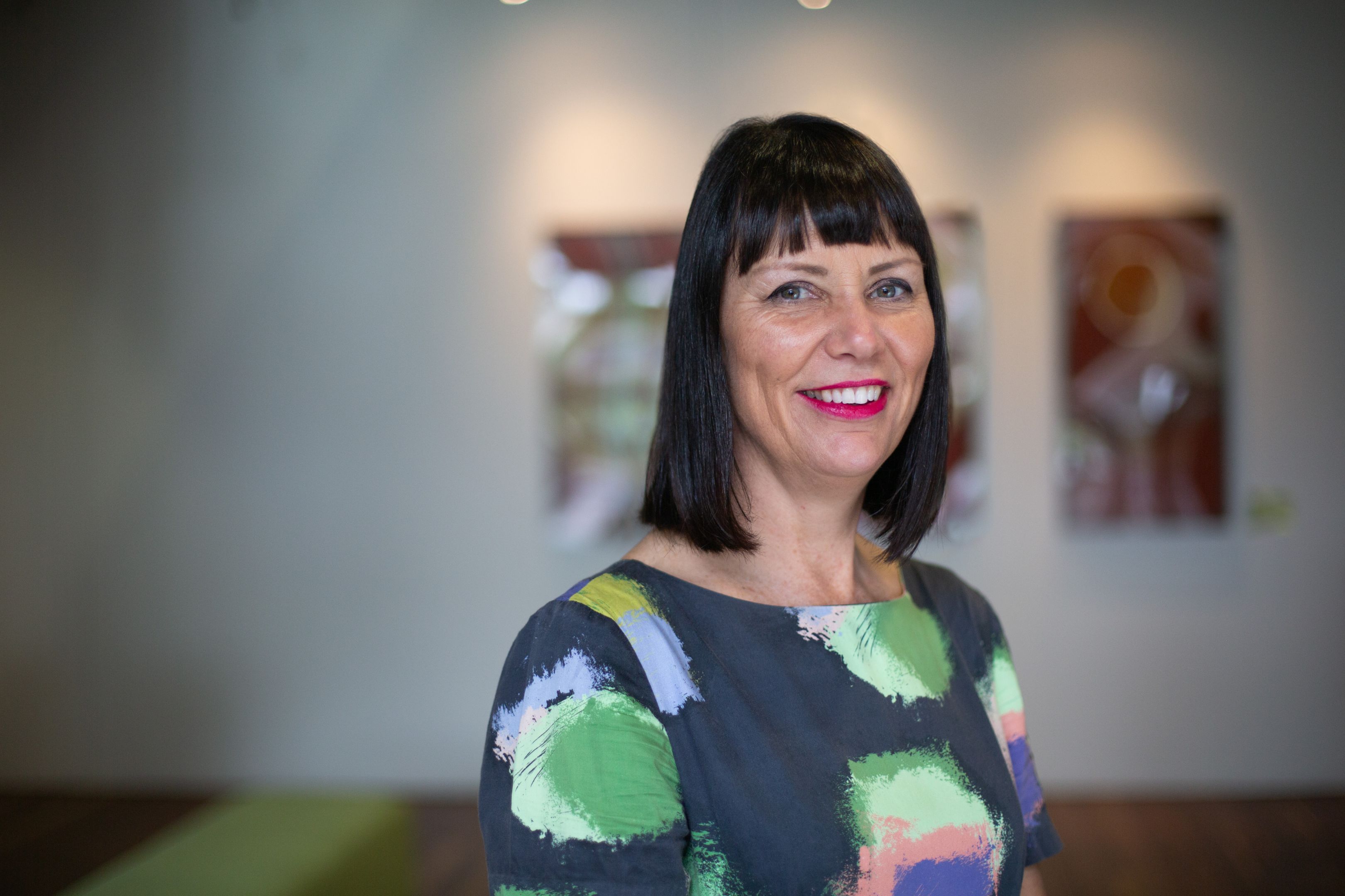 Image of a woman smiling in front of a blurred background