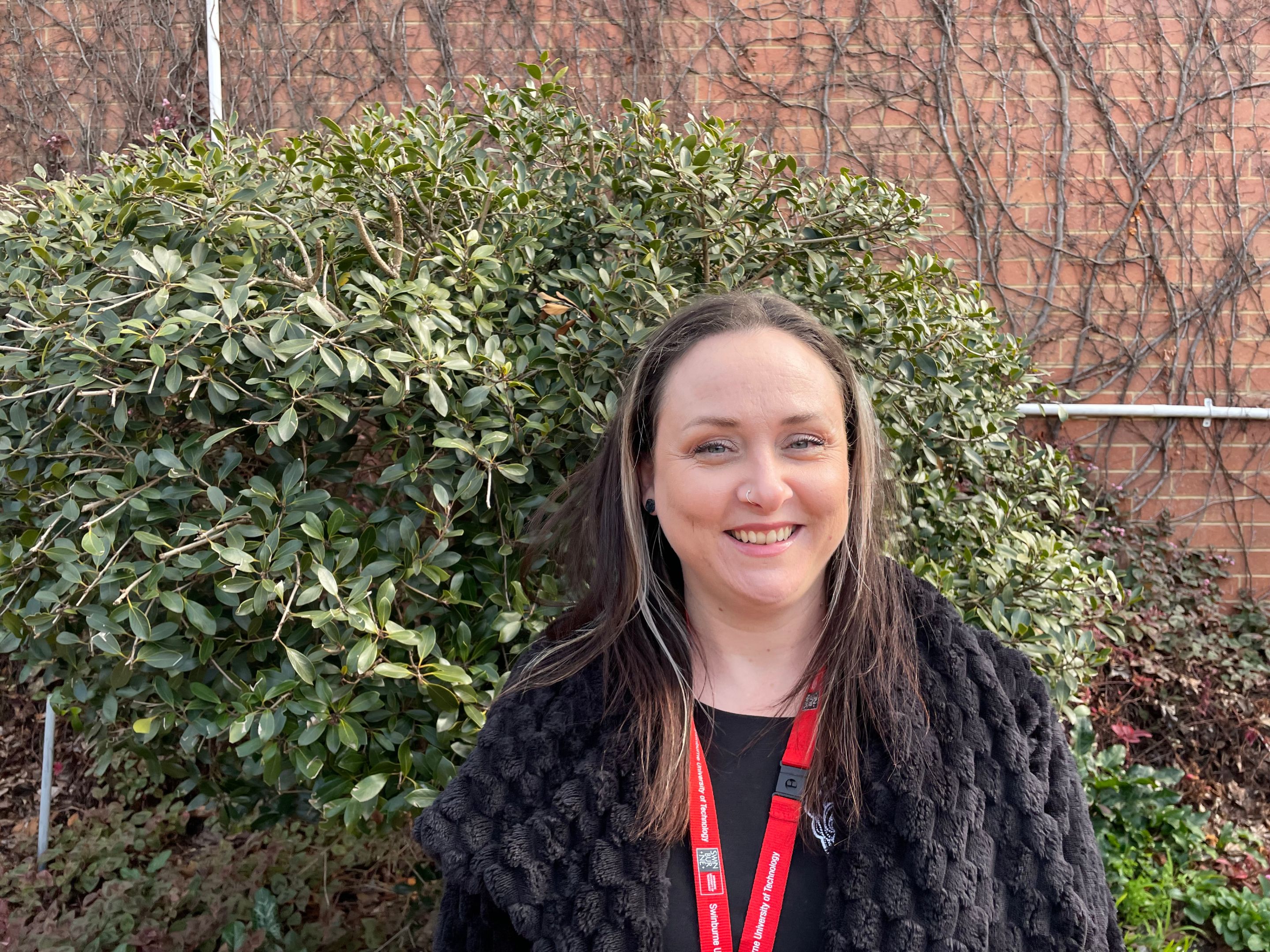 Sarah Wootten - student success coach woman with hair down standing outside wearing swinburne lanyard