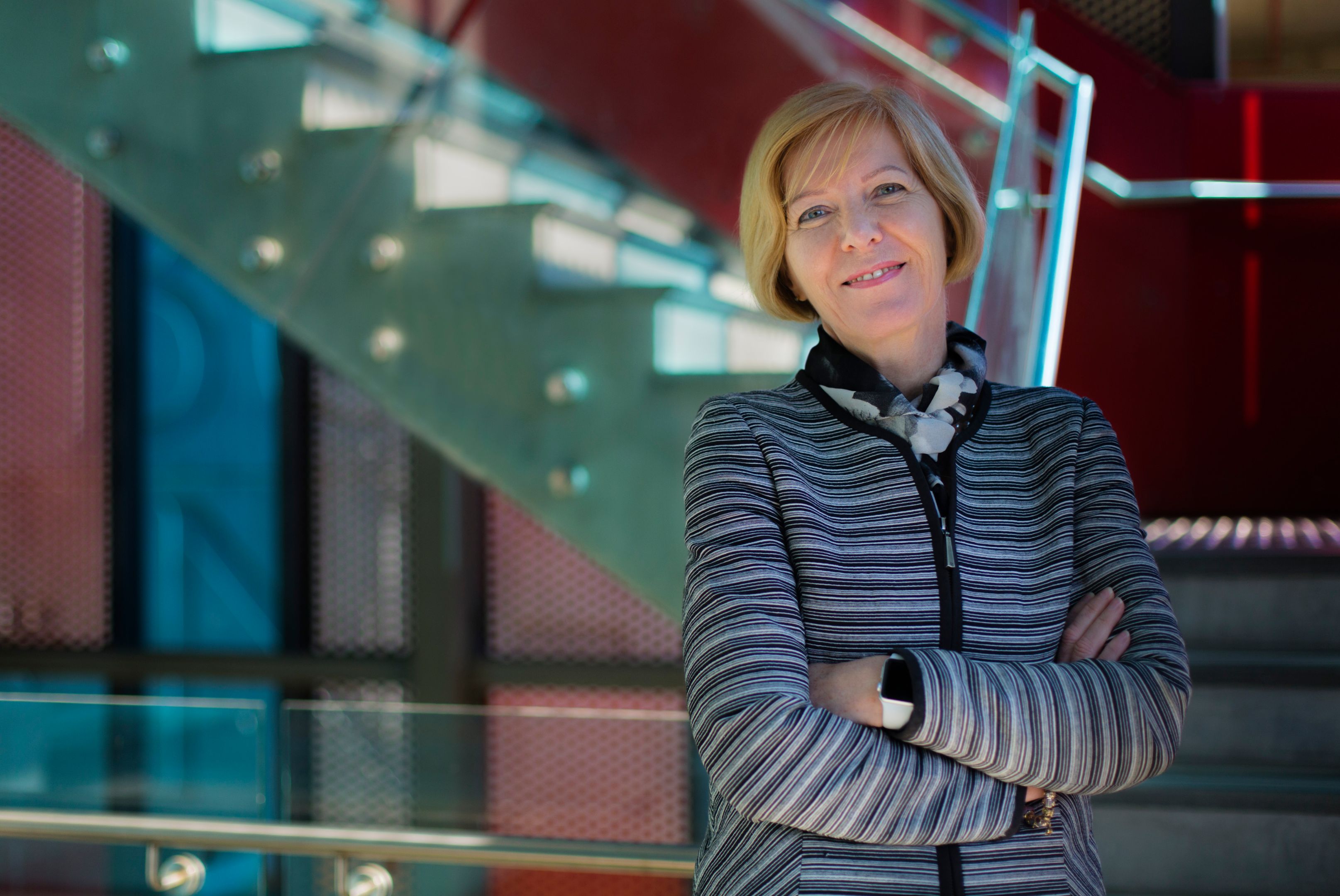 Vice-Chancellor Professor Pascale Quester Swinburne Vice-Chancellor Pascale Quester smiling with arms crossed wearing a striped cardigan in front of a stairwell