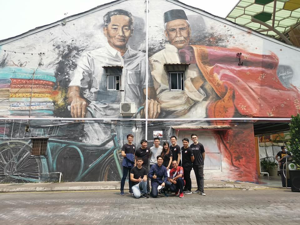 Sarawak alum Lim Jim Hong with employees from ARx Media Sarawak alum Lim Jim Hong with a group of his employees from ARx Media by a mural in Sarawak.