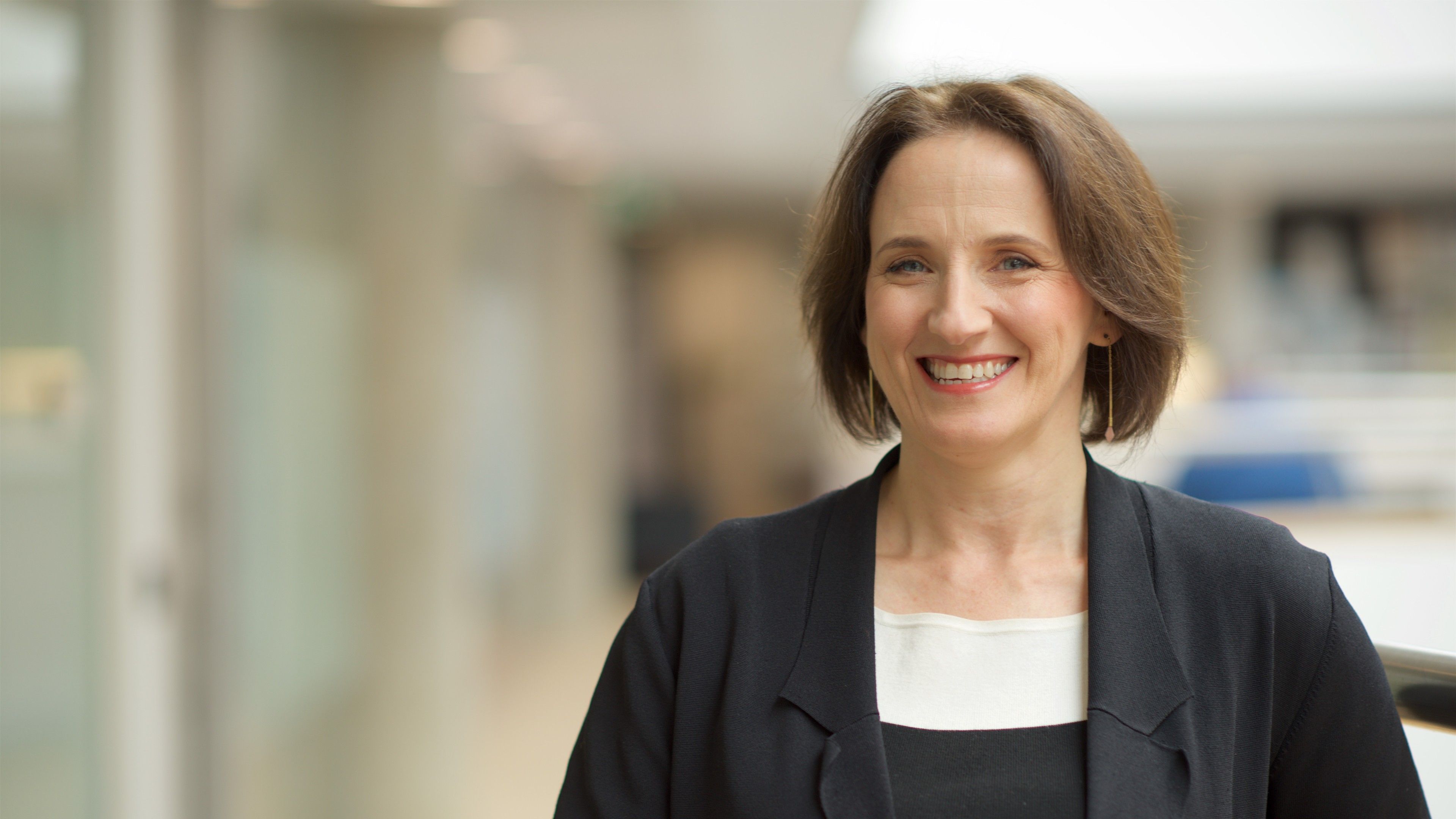 Nicole Lamond, AGSE campaign, 2017 Professional female smiles to camera at the AGSE building wearing a black blazer