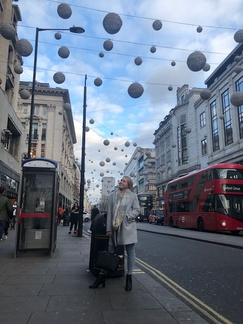 Study abroad and exchange student Chloe Female standing in a busy London street with Christmas decorations overhead