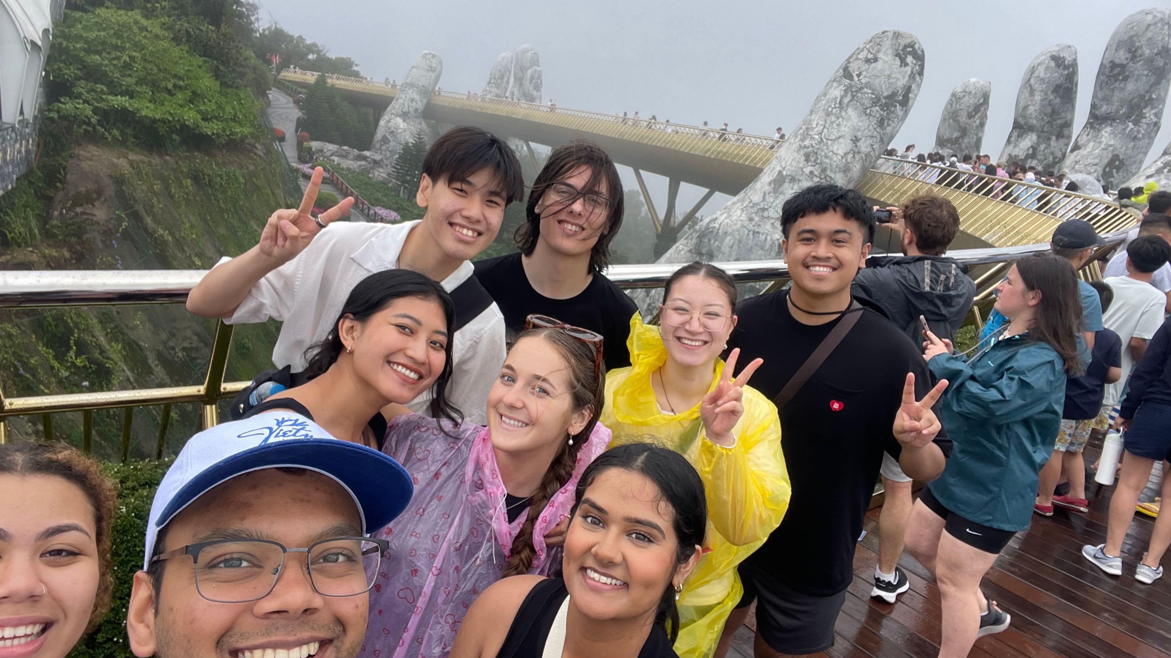 Vietnam Law, Governance and Culture Tour: Golden Bridge Selfie of a group of students on Golden Bridge, Vietnam, huge stone hands hold up curving bridge in the mist