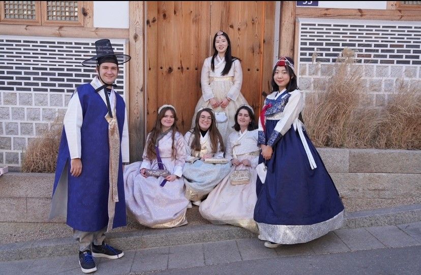 Study Abroad student Henry Edwards Henry Edwards on the left in traditional blue Korean hanbok posing with 5 other girls in hanbok