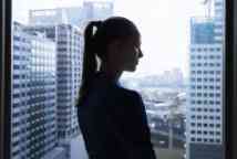 Istock young Lady standing in the shadows near window