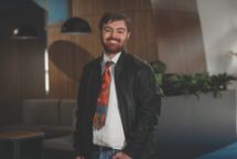 Person standing front on smiling at camera.
