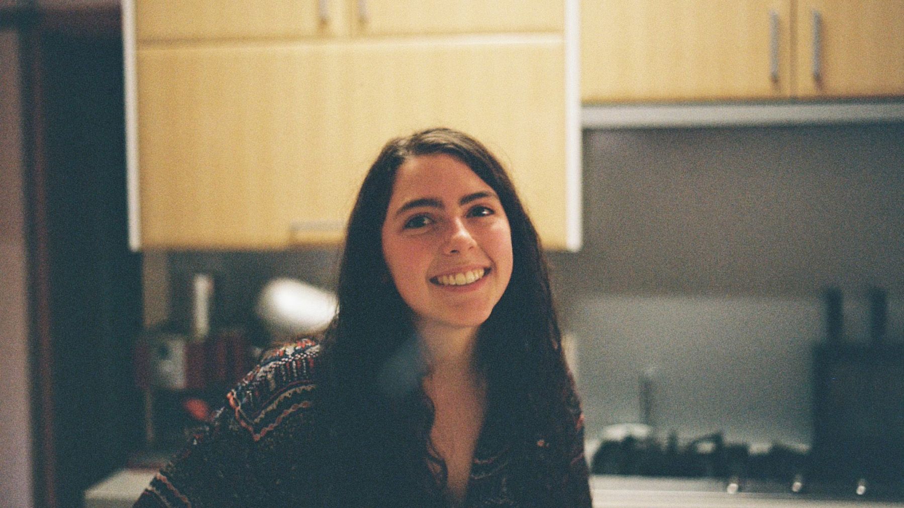 Placement student Claudia Claudia, a young female student with brown hair, standing and smiling in a kitchen.