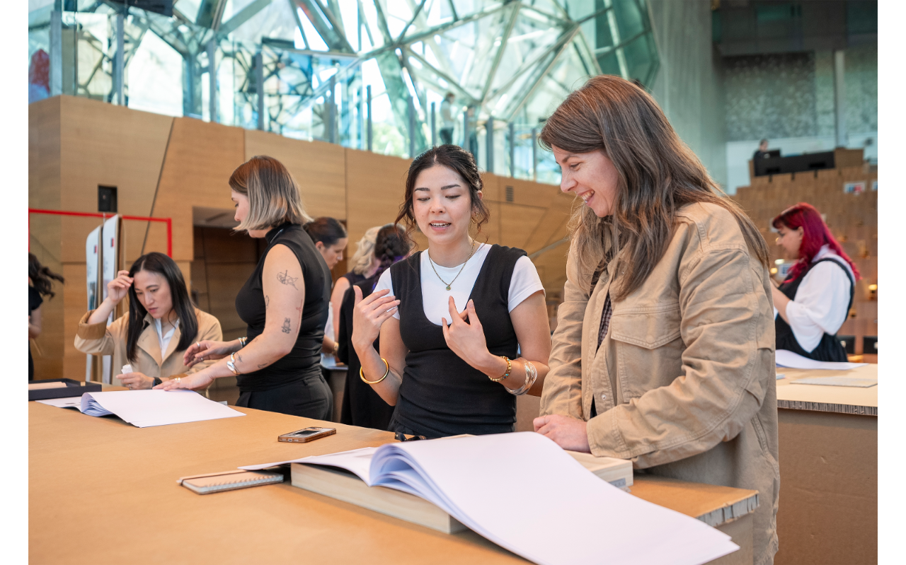 Two people looking at a portfolio at a Industry Presentation and Networking Event