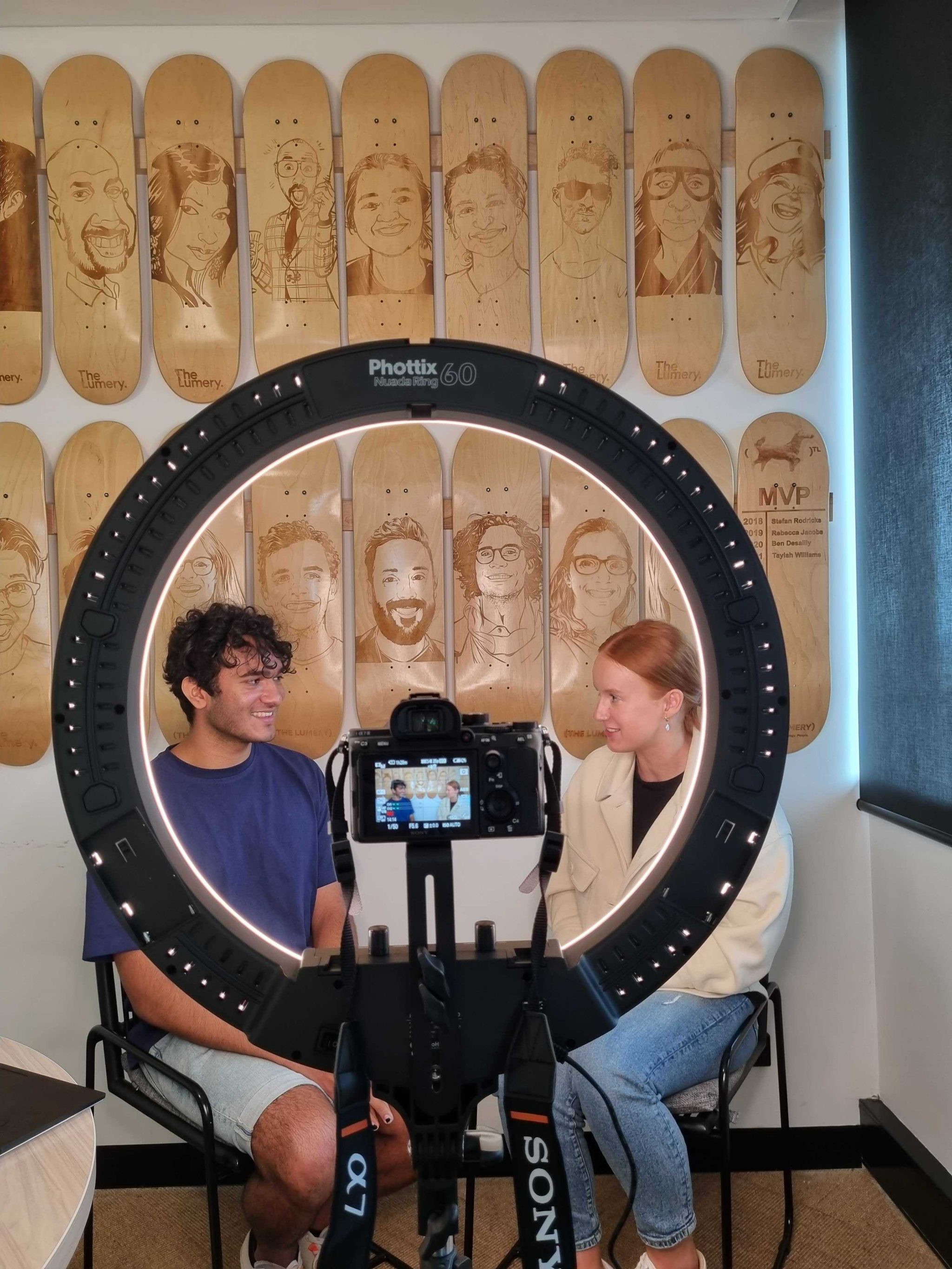 Student Olivia recording a video with her colleague at the Lumery Student Olivia recording a video with her colleague in front of a camera and a ring light